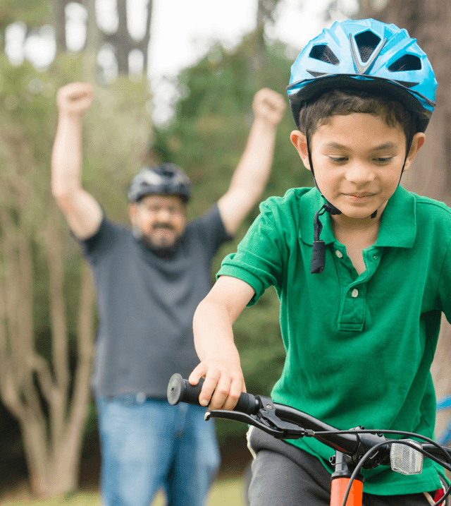 Foster carer teaching foster child to ride a bike